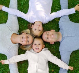 Family lying on the grass and smiling top view